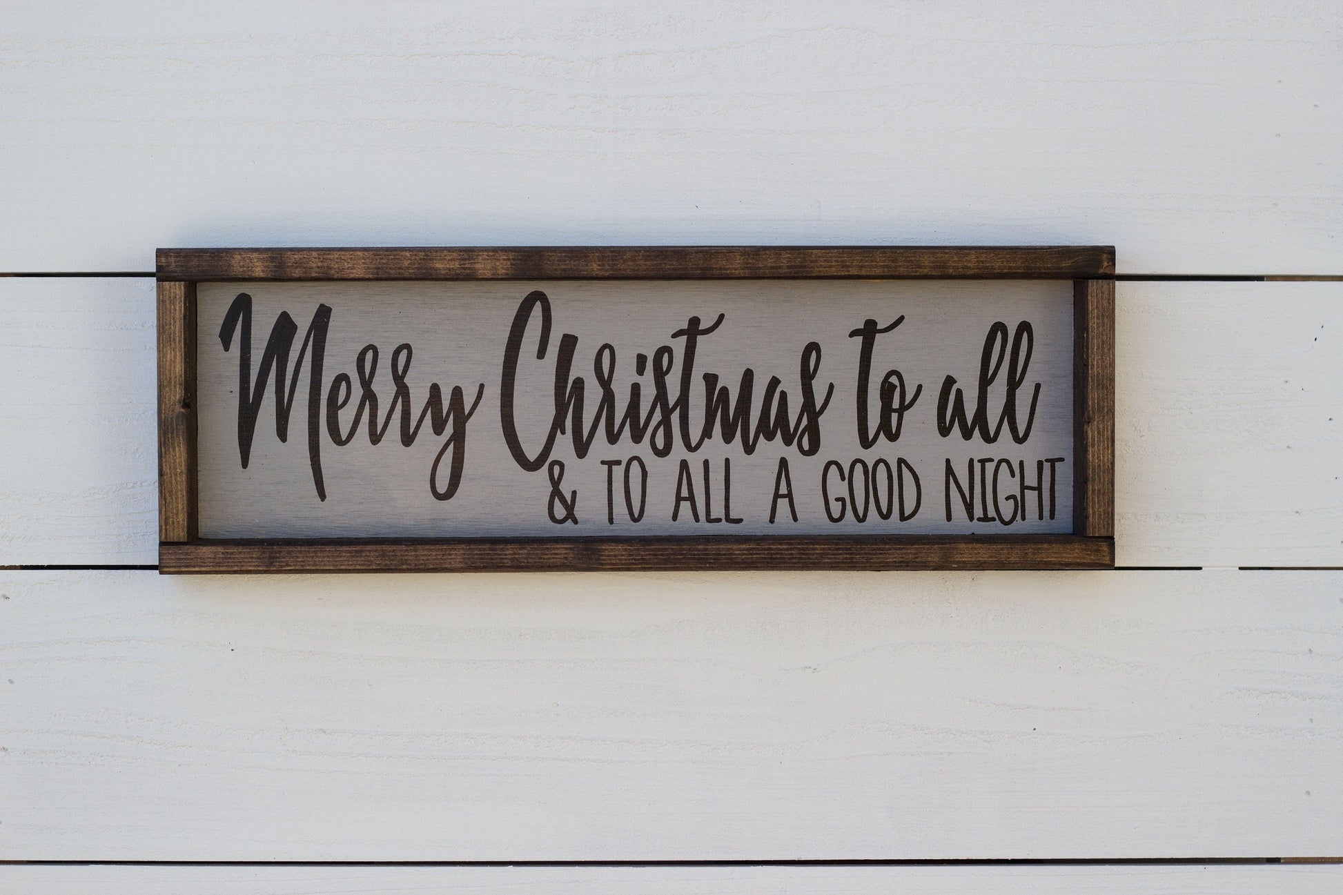 Wooden sign with 'Merry Christmas to all & to all a good night' text on a white wooden background