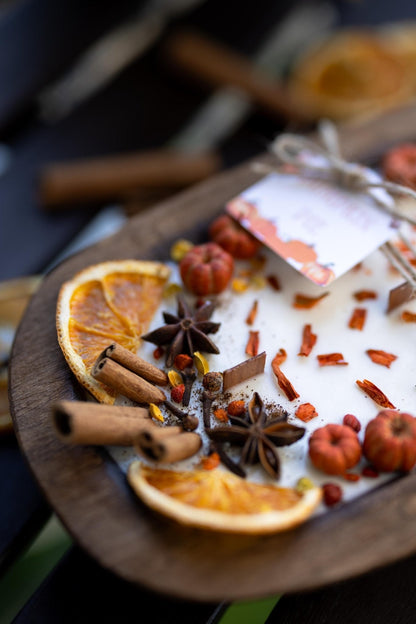 Spice mix with oranges, cinnamon sticks, and star anise on a wooden board.