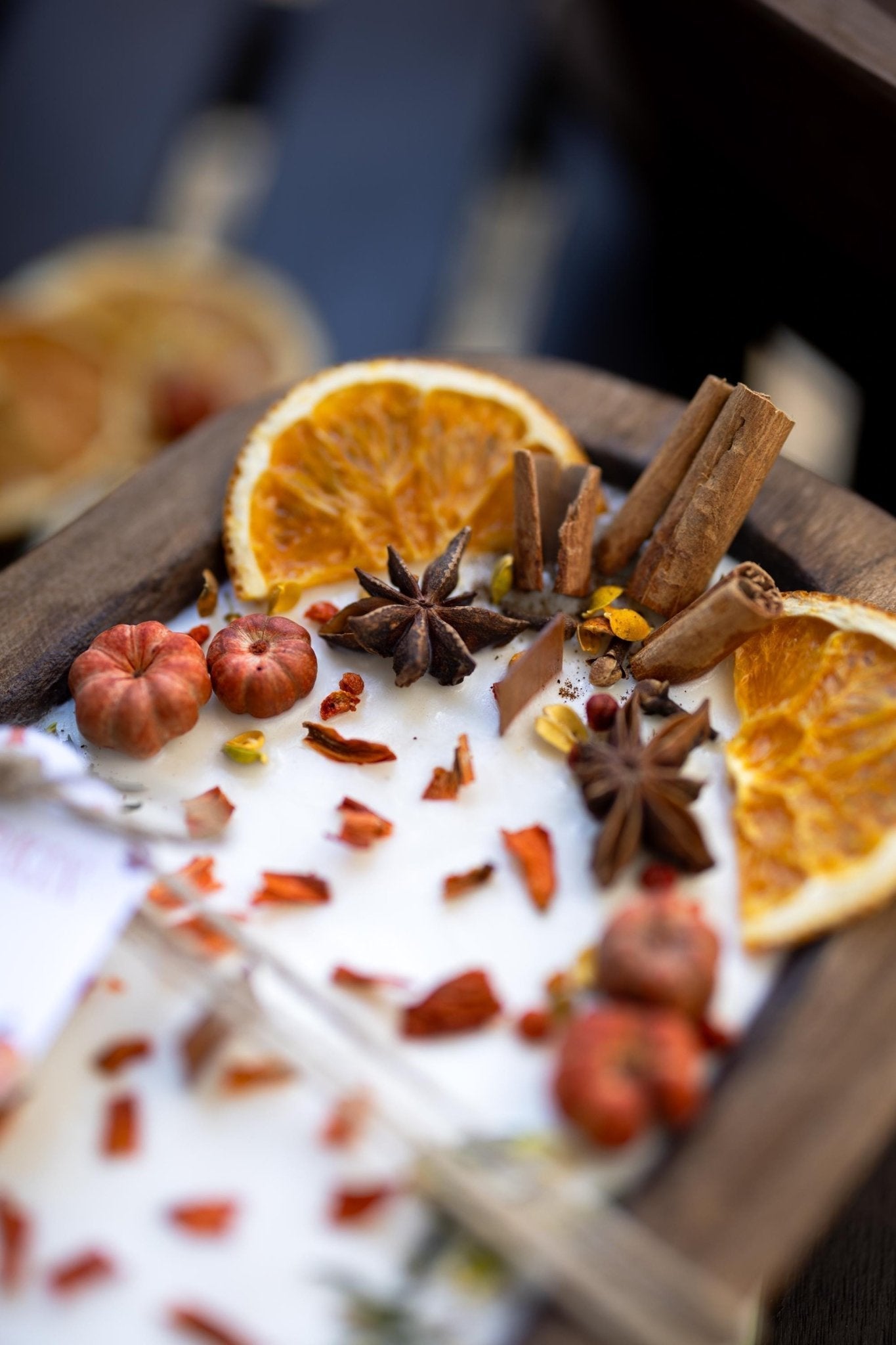 Decorative wreath with dried oranges, cinnamon sticks, and star anise on a white surface.