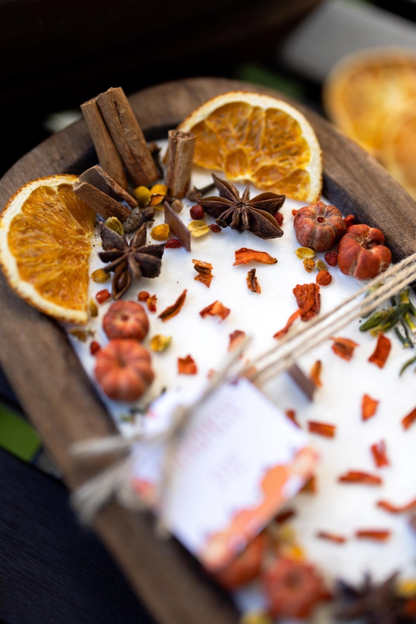 Spice mix with cinnamon sticks, oranges, and star anise on a wooden tray.