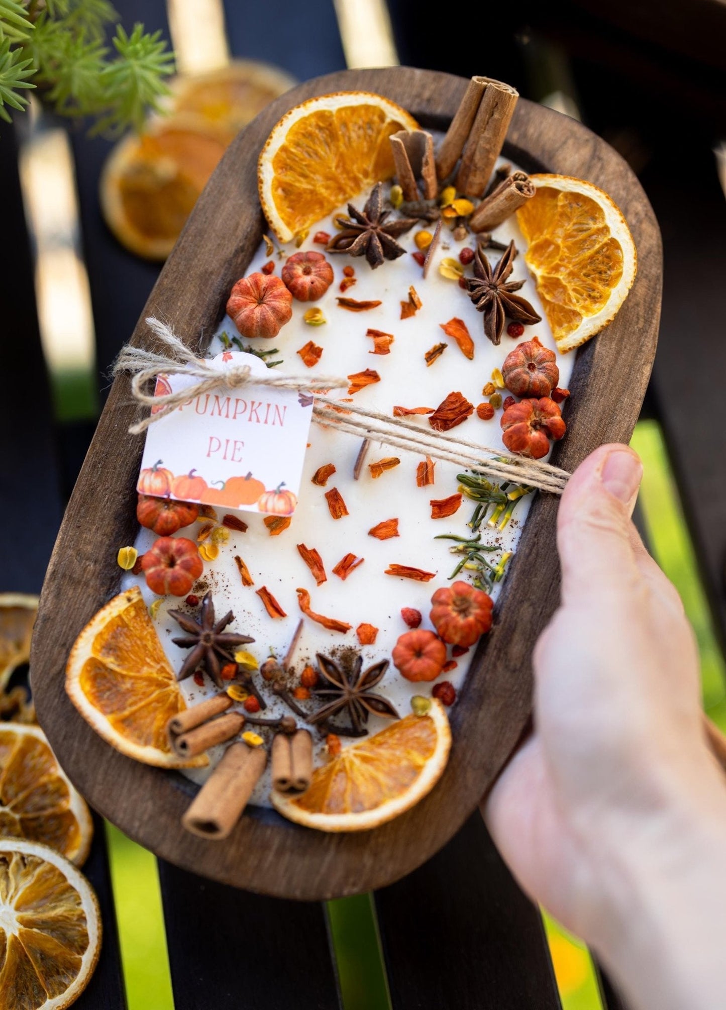 Spice blend with oranges, cinnamon, and star anise on a wooden board.