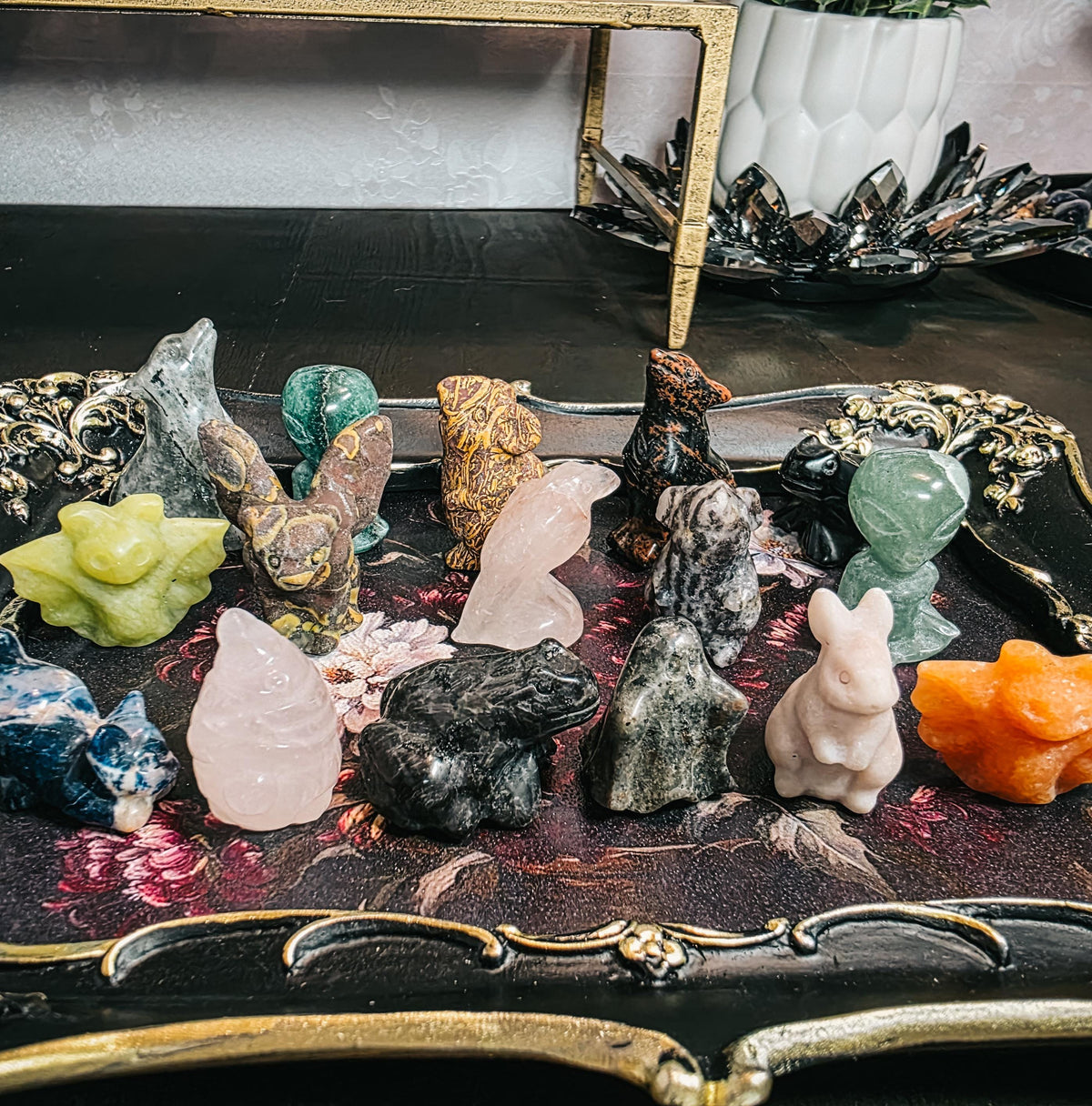 Collection of various crystal figurines on a decorative surface with a blurred background