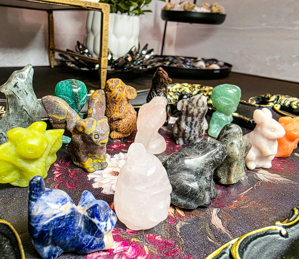 Collection of various colorful crystal figurines on a decorative surface.