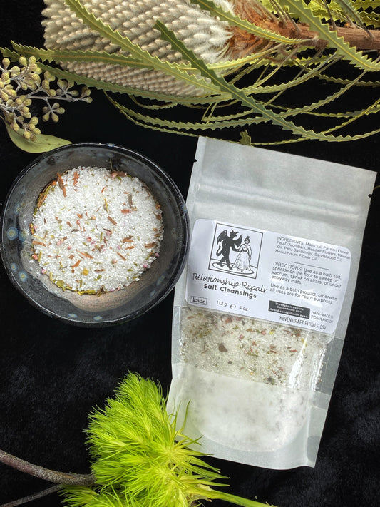 Salts in a bowl and a labeled bag on a dark background with greenery