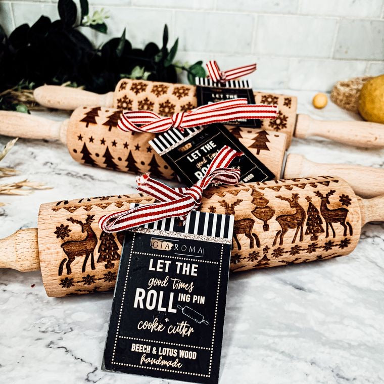 Wooden rolling pins with embossed designs and gift tags on a marble surface.