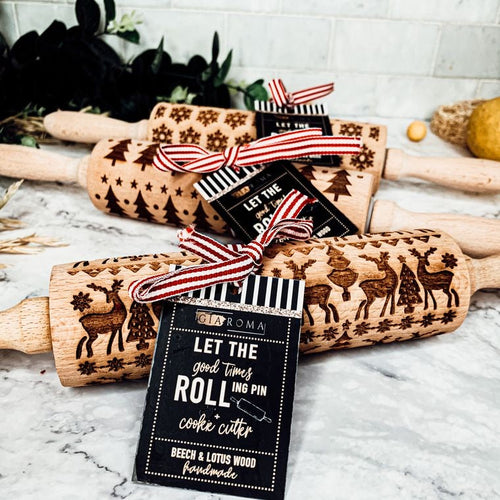Wooden rolling pins with embossed designs and gift tags on a marble surface.