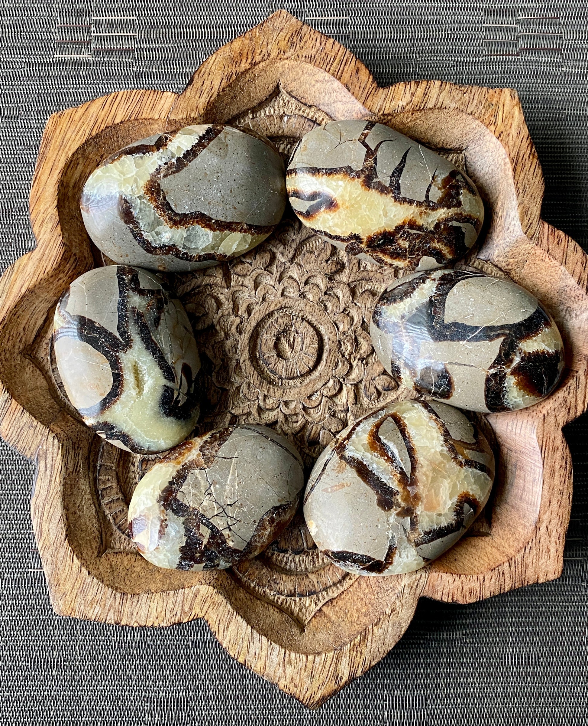 Decorative stone bowl with marbled stones on a textured surface