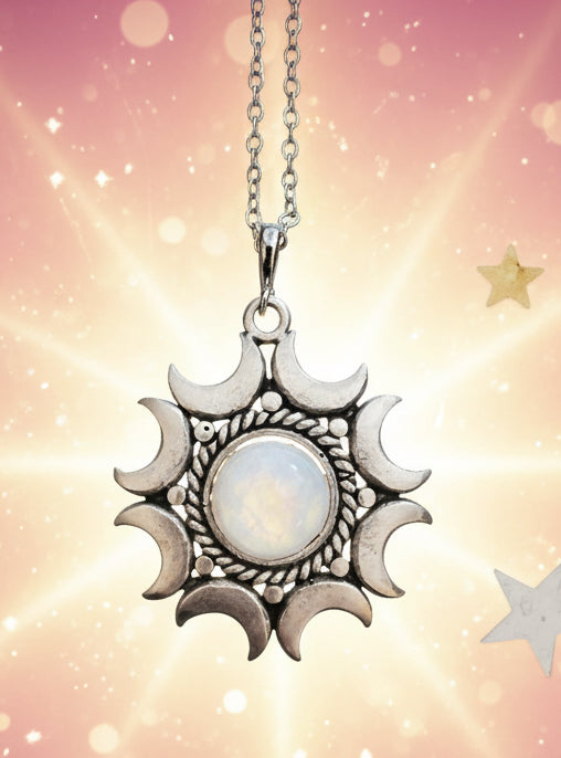 Silver sun and moon pendant necklace on a black background with stars.