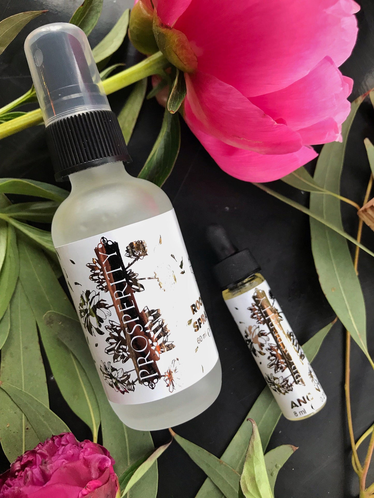 Two bottles with labels on a leafy background