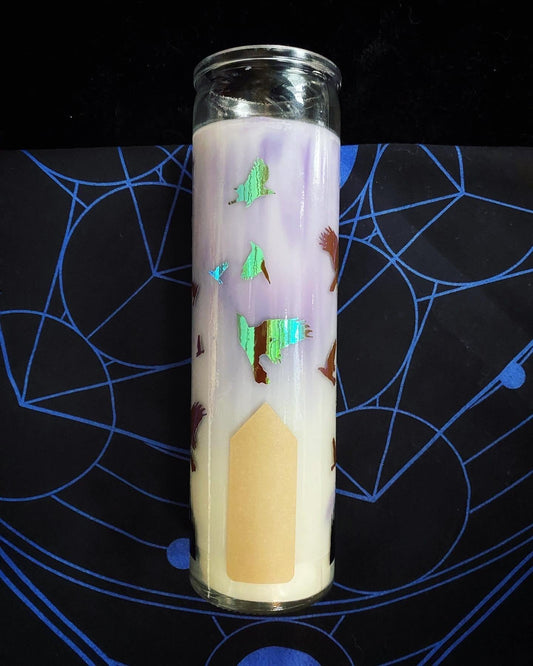 Decorative candle with a house design on a black surface with blue patterns