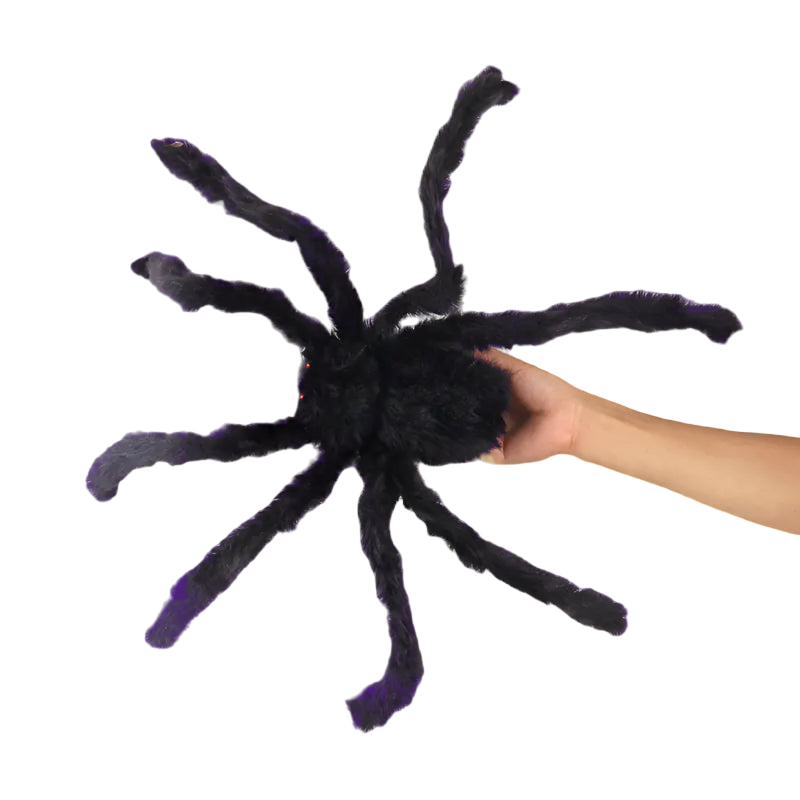Large black spider plush toy held by a hand on a white background