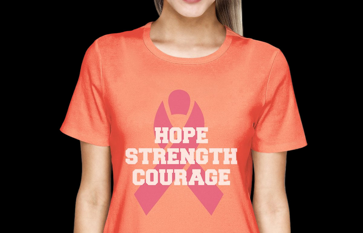 Person wearing an orange t-shirt with a pink ribbon and text 'Hope Strength Courage' on a white background