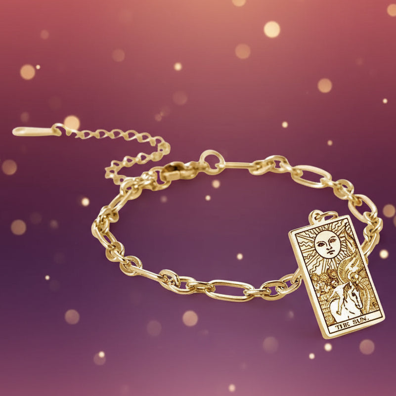 Gold bracelet with tarot card charm on a white background