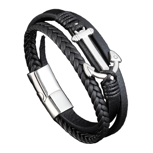 Black braided leather bracelet with silver anchor charm on a dark wooden surface