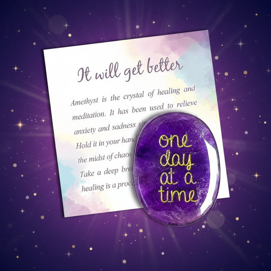 Purple crystal with 'One day at a time' text on a colorful card with motivational message.