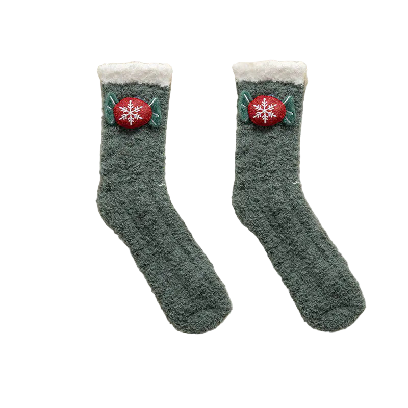 Pair of green socks with snowflake buttons on a white fluffy surface