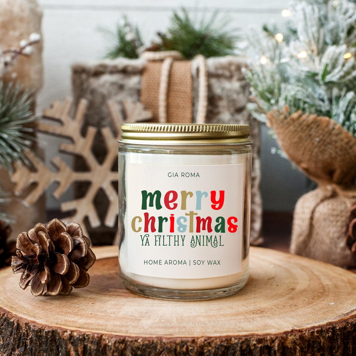Candle with a humorous label on a wooden surface with Christmas decorations.