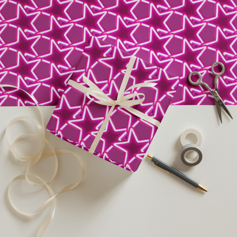 Gift with pink star patterned paper, ribbon, scissors, and tape on a white surface.