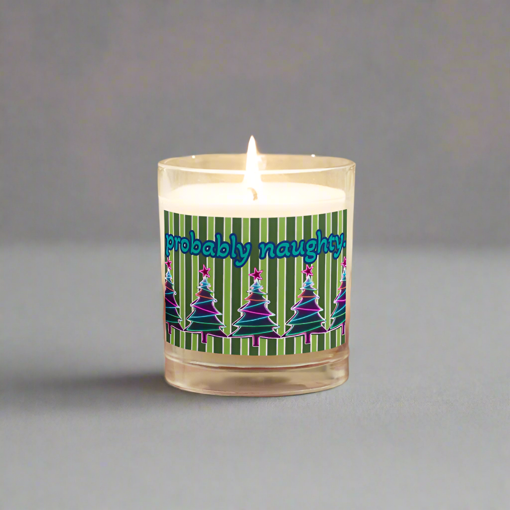 Candle with 'probably naughty' text held by a person wearing a beige sweater.
