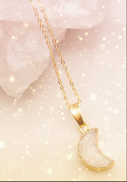 Gold necklace with a semi-precious stone pendant on a white background