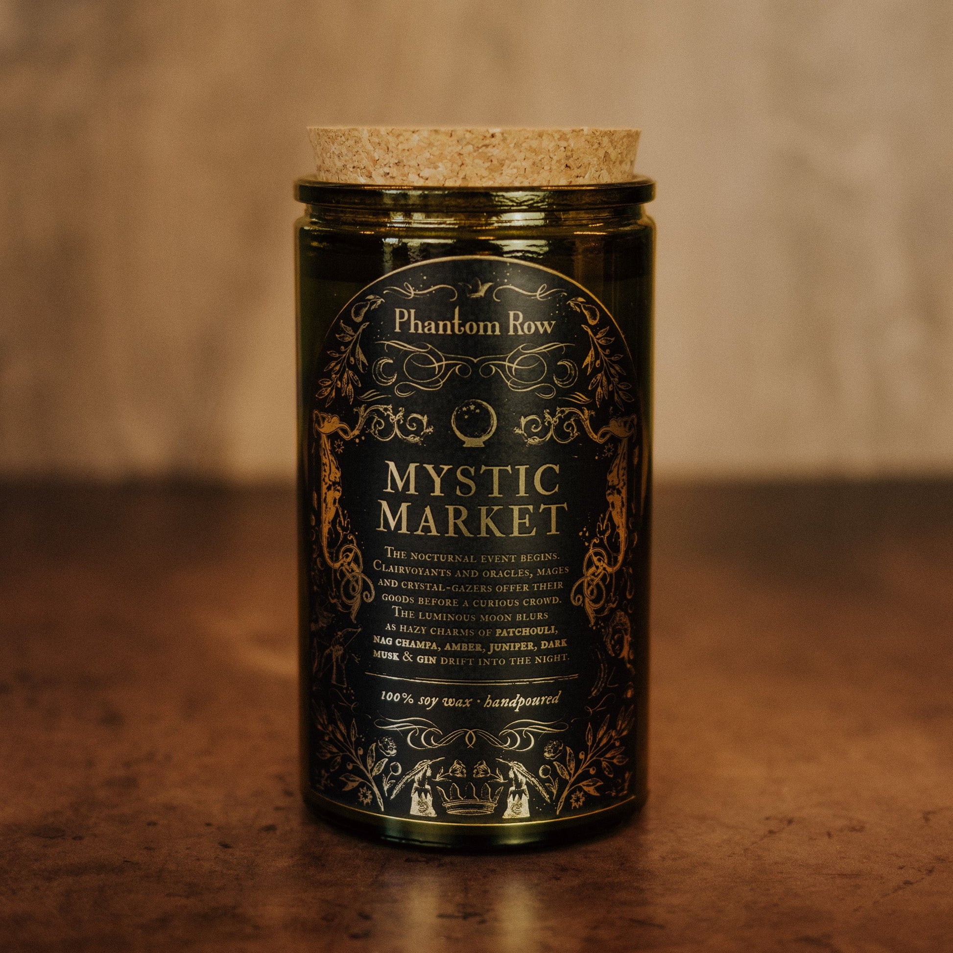 Jar of 'Mystic Market' candle by Phantom Row on a wooden surface with a blurred background