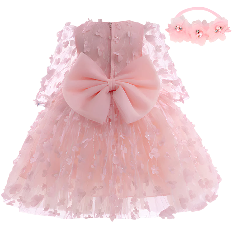 Pink lace dress with a large bow and matching headband on a white background