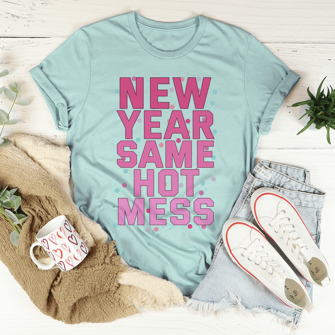 Light blue t-shirt with pink text 'NEW YEAR SAME HOT MESS' on a white surface with casual items.