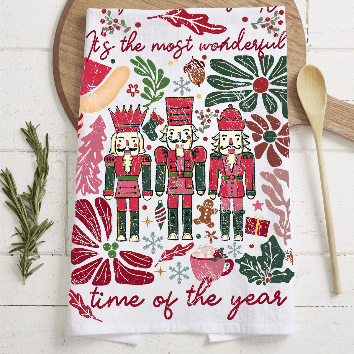 Decorative towel with Christmas-themed design featuring nutcrackers and floral elements on a wooden surface.