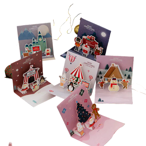 Collection of Christmas-themed pop-up cards on a festive background with lights and decorations.