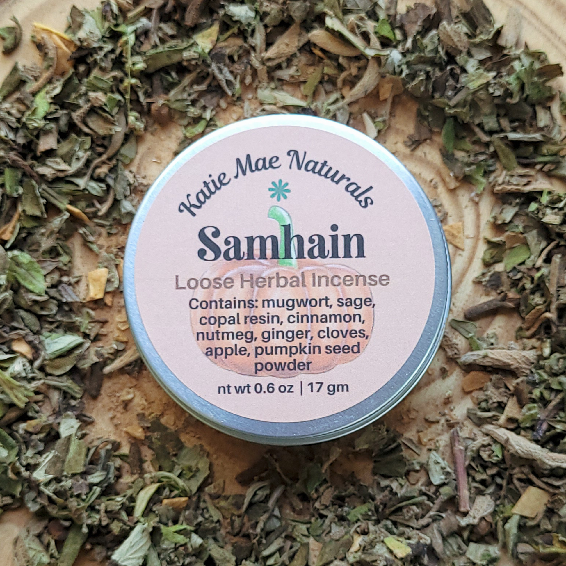 Katie Mae Naturals Samhain Loose Herbal Incense container on a bed of dried herbs