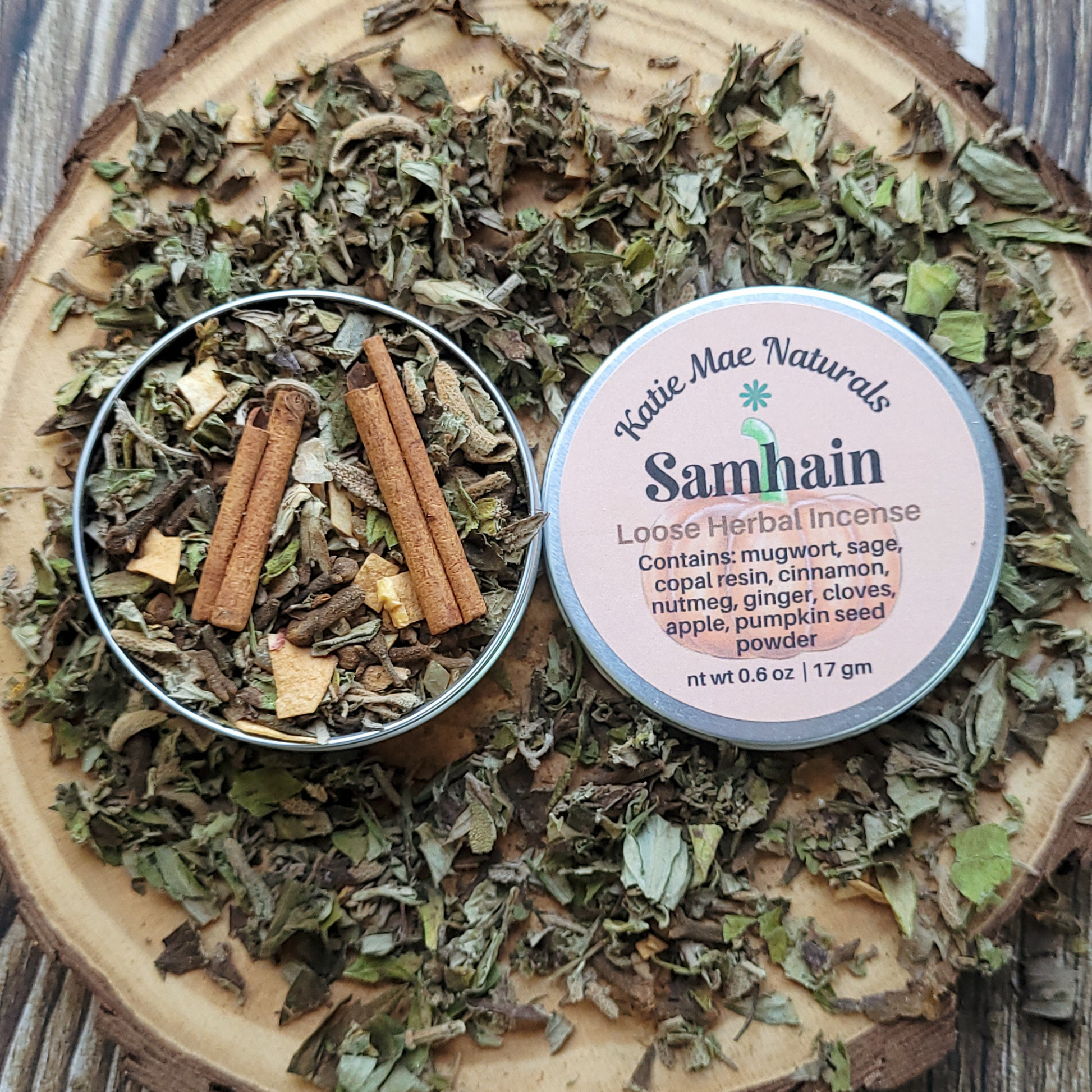 Katie Mae Naturals Samhain loose herbal incense on a wooden surface with dried herbs and cinnamon sticks.