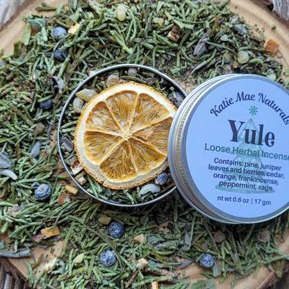 Katie Mae Naturals Yule loose herbal incense with dried orange slice and herbs on a wooden surface