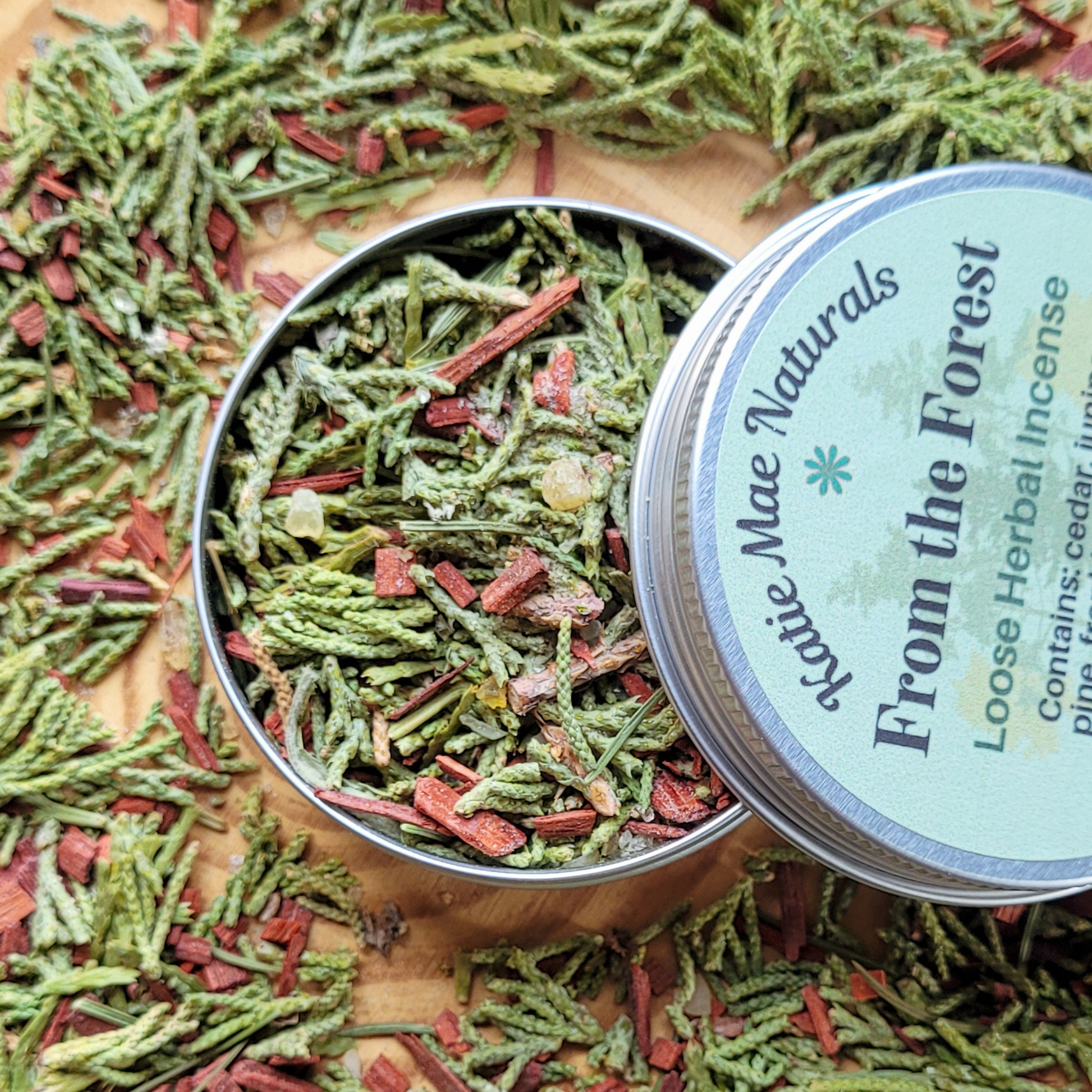 Herbal incense in a tin with a 'From the Forest' label on a wooden surface.