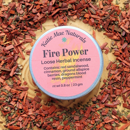 Katie Mae Naturals Fire Power Loose Herbal Incense surrounded by red sandalwood chips.