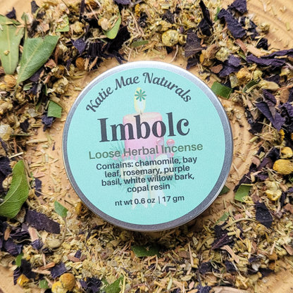 Katie Mae Naturals Imbolc loose herbal incense container surrounded by dried herbs