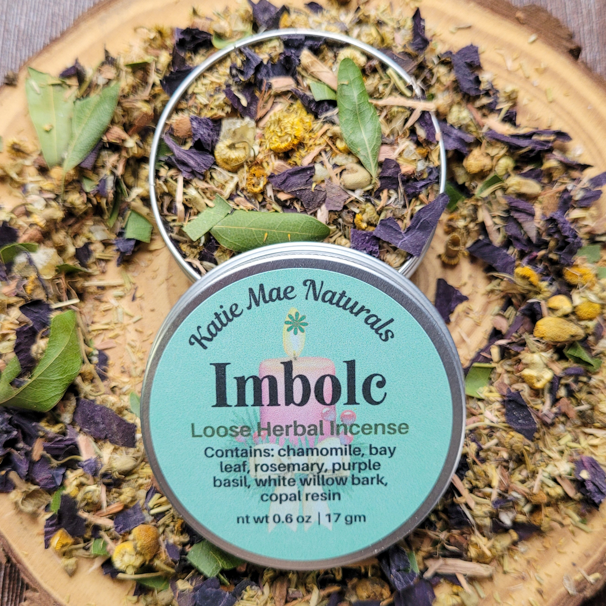 Katie Mae Naturals Imbolc loose herbal incense on a wooden board with dried herbs.