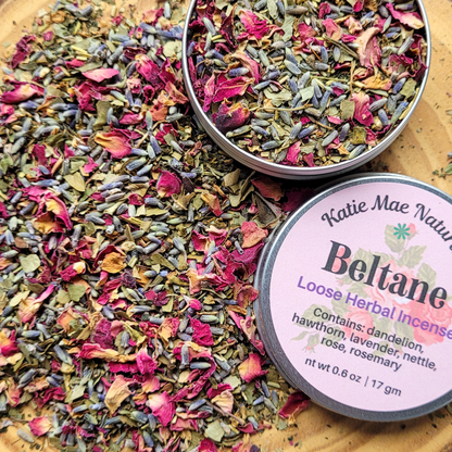Bowl of colorful loose herbal incense with a label on a wooden surface