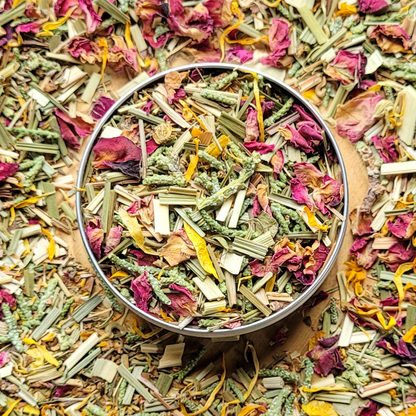 Bowl of mixed dried herbs and flowers on a bed of similar herbs