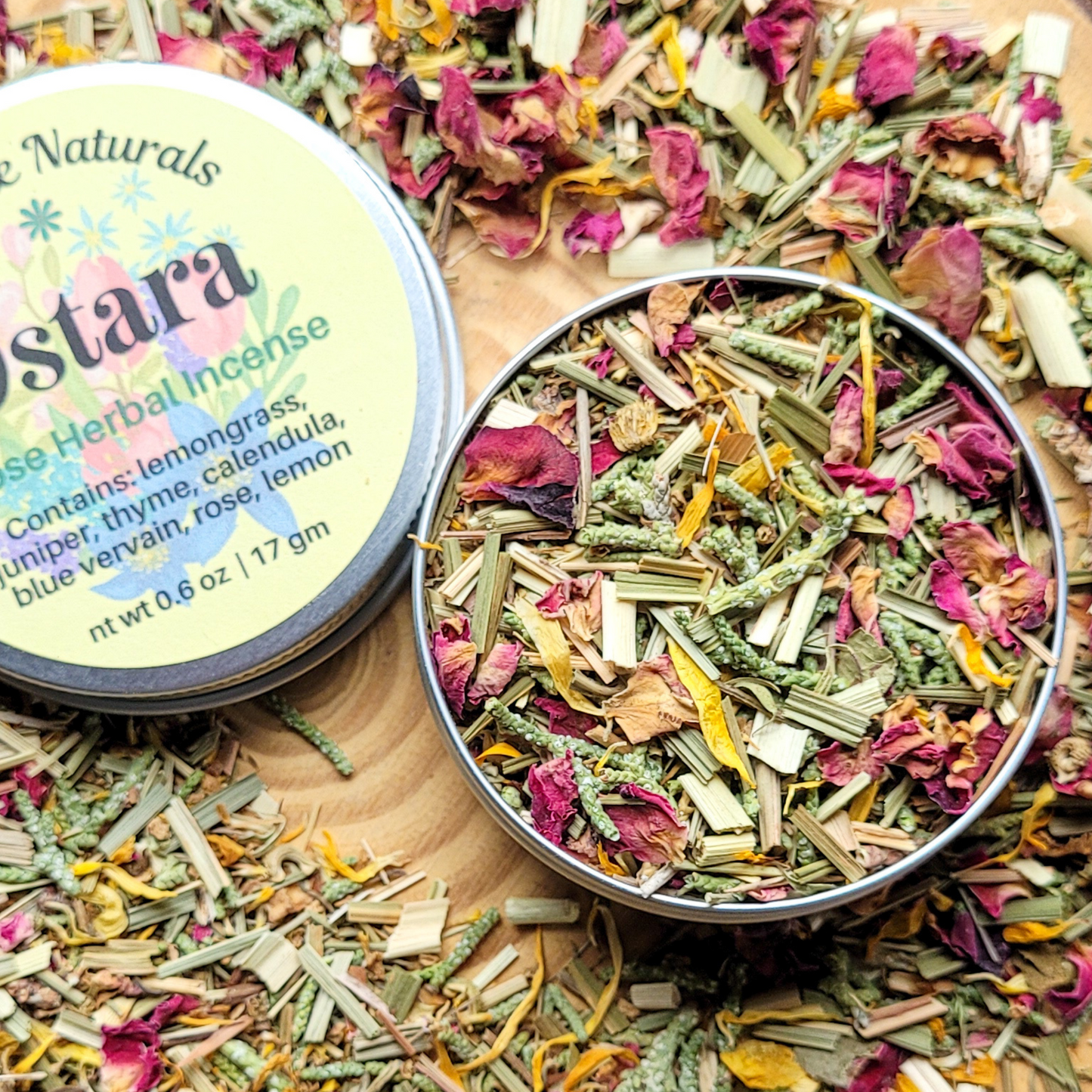 Herbal incense mix in a tin with a colorful label on a wooden surface.