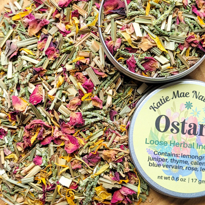 Herbal mix with a tin labeled 'Katie Mae Naturals Ostarine' on a wooden surface.