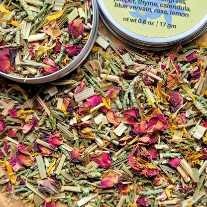 Herbal mixtures in tins with visible ingredients on a wooden surface