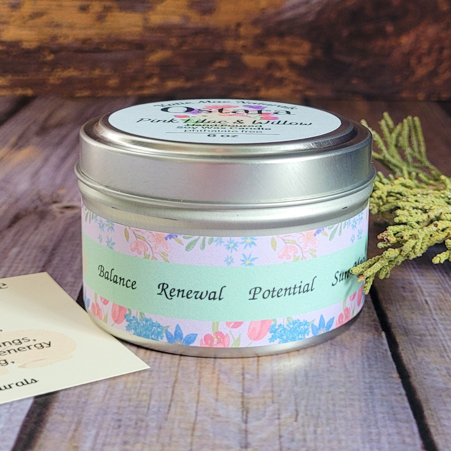 Candle tin with floral label on a wooden surface