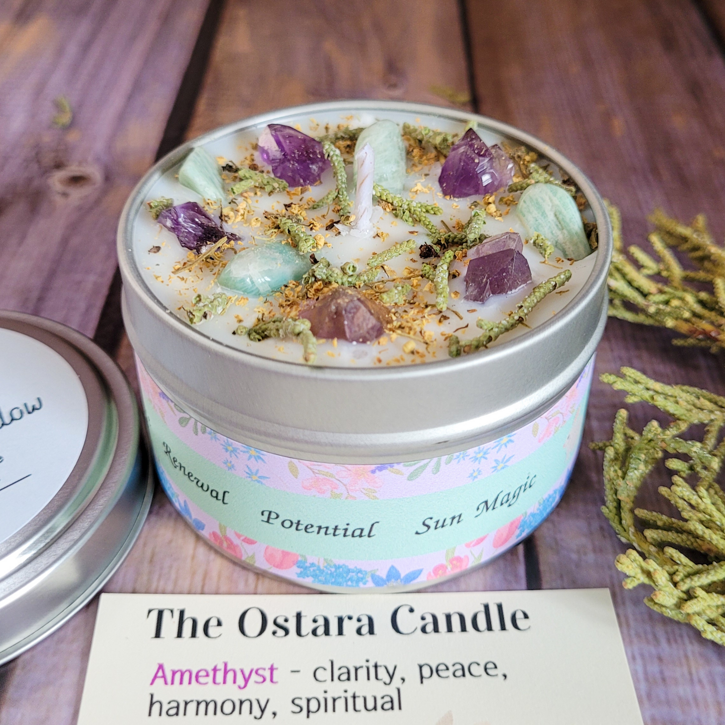 Ostara Candle with amethyst stones in a decorative tin on a wooden surface