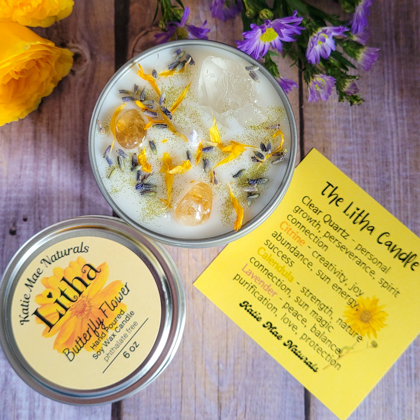 Butterfly pea flower candle in a tin with a label on a wooden surface.