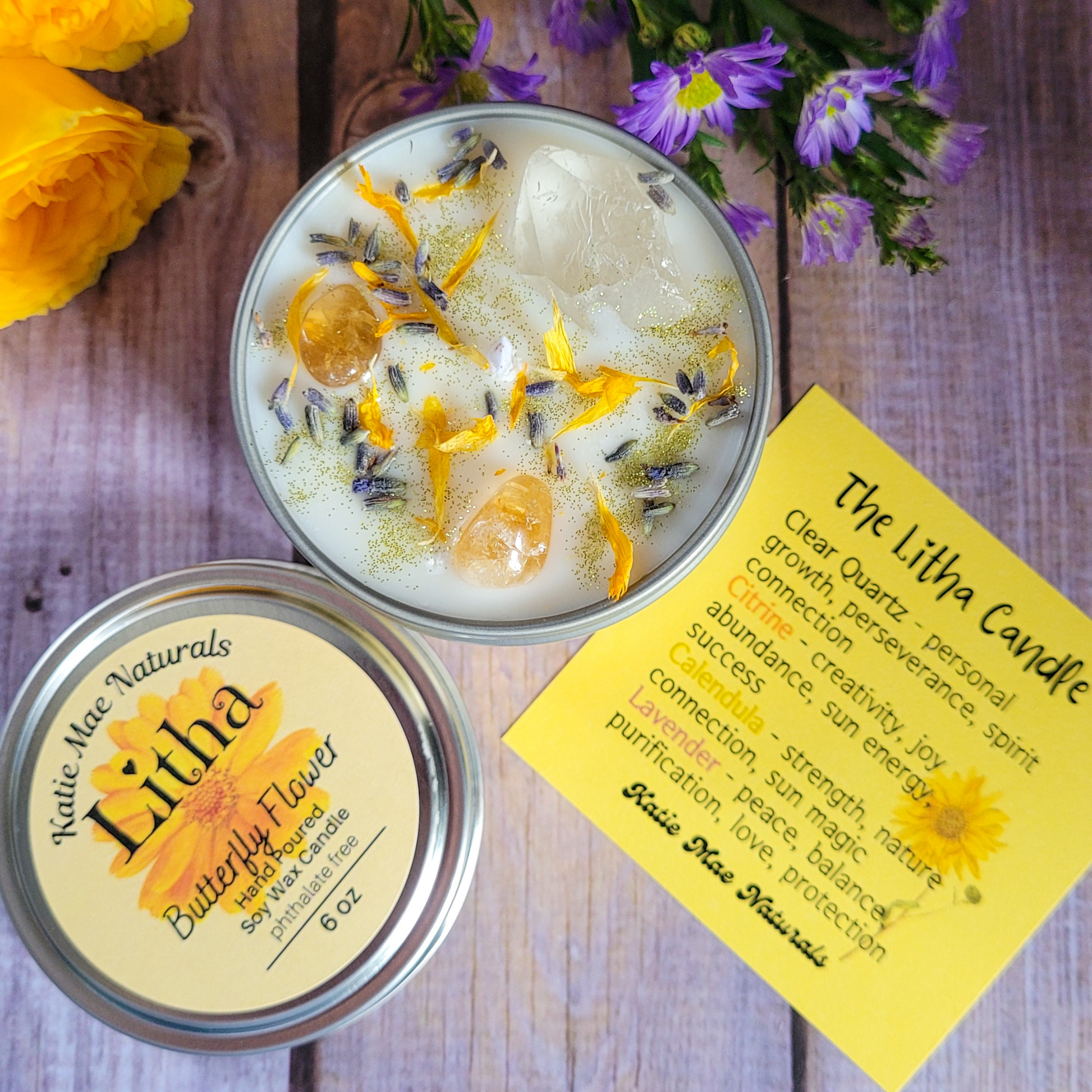 Butterfly pea flower candle in a tin with a label on a wooden surface.