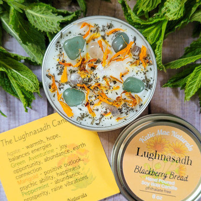 Decorative candle with stones and herbs on a wooden surface with a leafy background