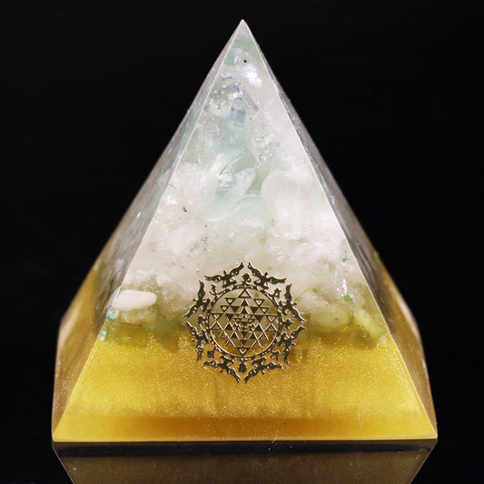 Pyramid-shaped crystal with Sri Yantra symbol on a black background