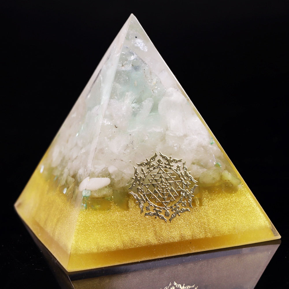 Pyramid-shaped object with gold base and white top on a black background