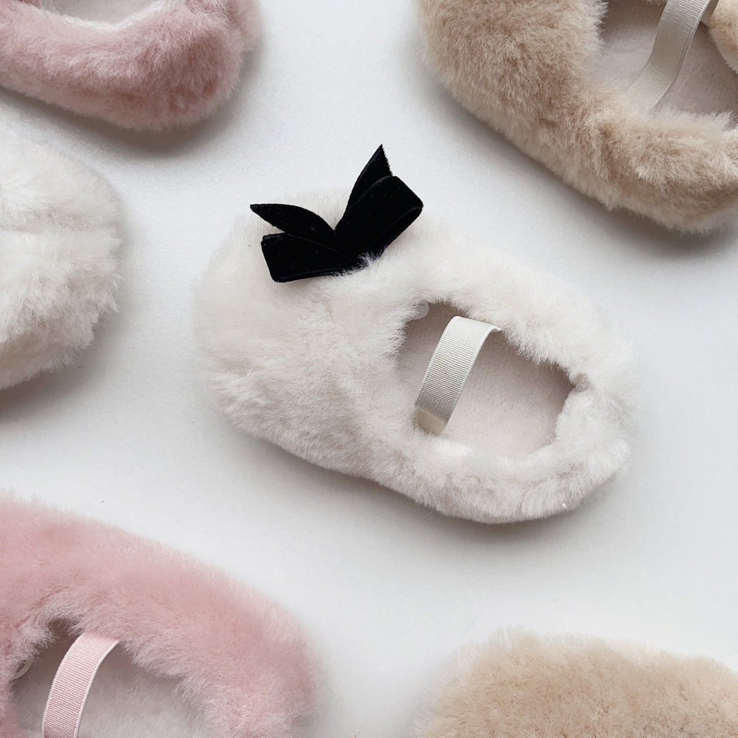 Fluffy slippers with a black bow on a light background