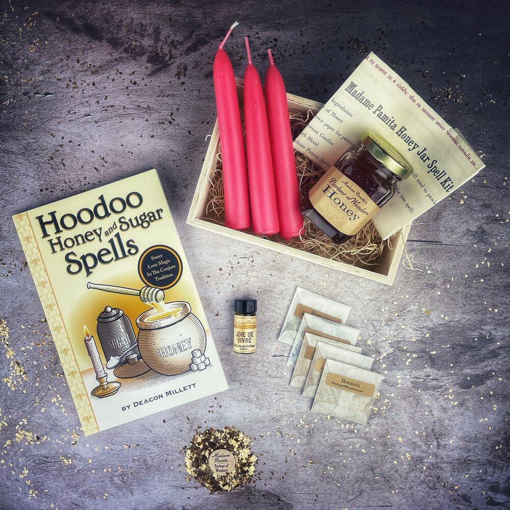 Hoodoo Honey and Sugar Spells kit with candles, honey, and book on a textured surface